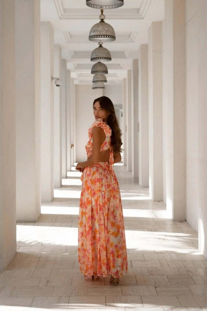 Amira – Vestido maxi sin espalda con estampado floral, volantes y cut-outs