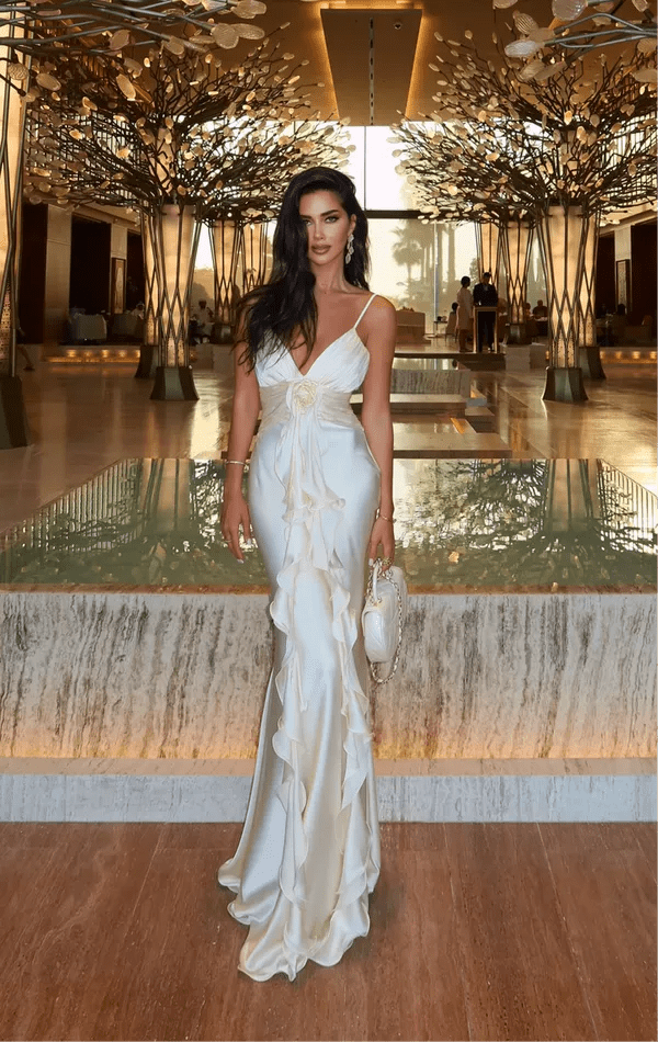 Elena – Maxivestido en marfil con volantes y detalle de rosa